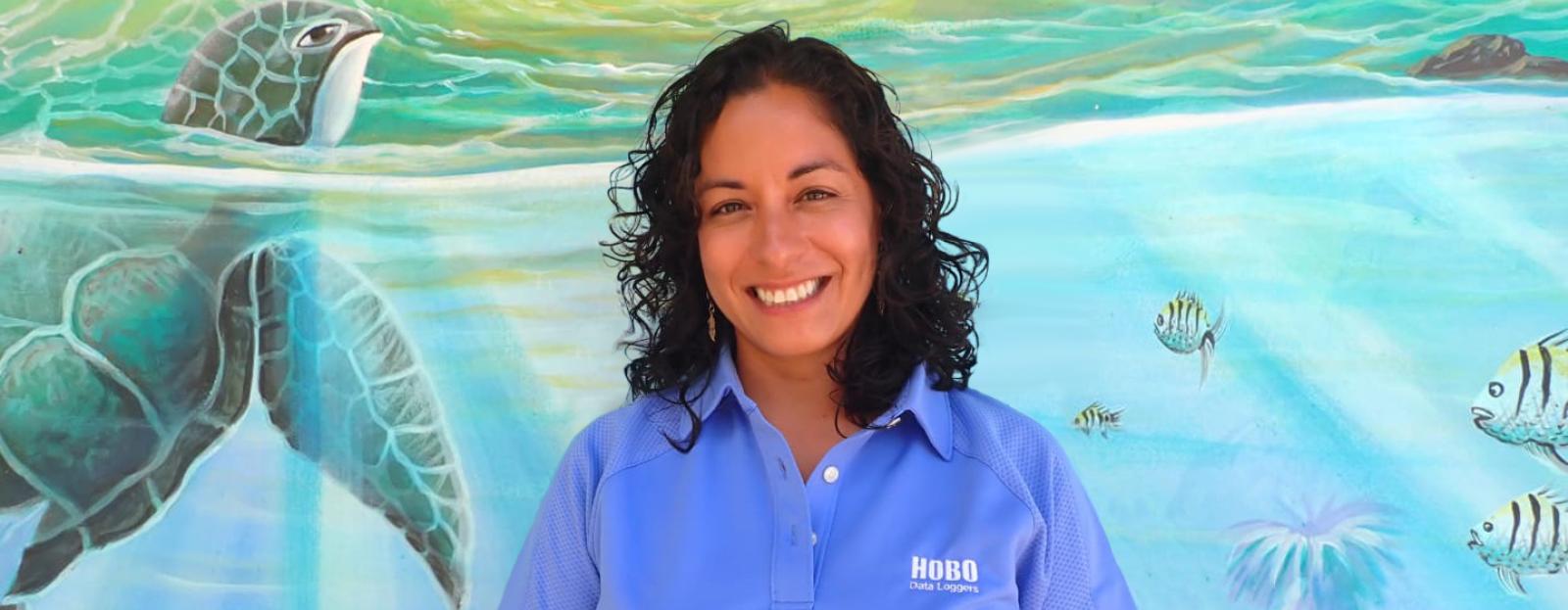 Andrea Rivera-Sosa standing in front of turtle mural