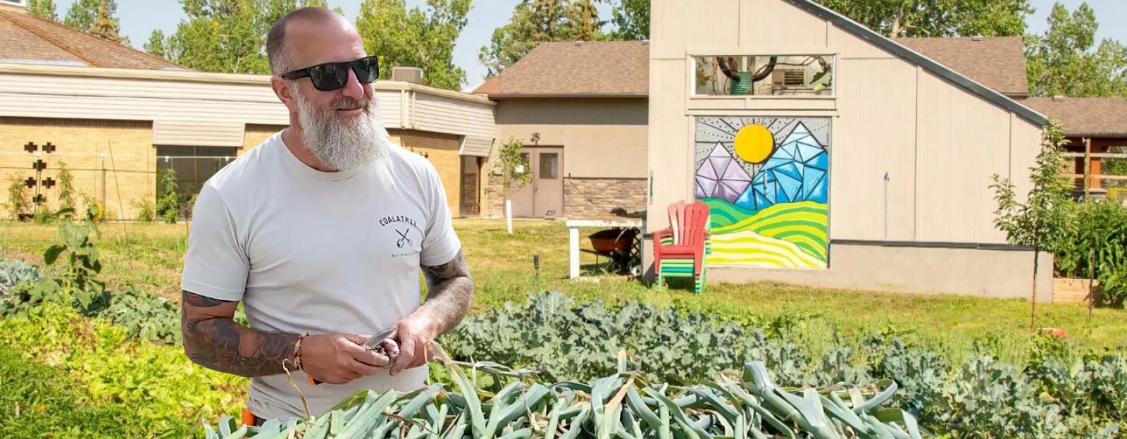 Vaden Somers in front passive solar greenhouse