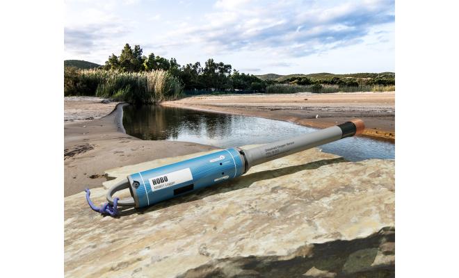Bluetooth data logger with dissolved oxygen sensor sitting on rock adjacent to a river bed with receded shoreline