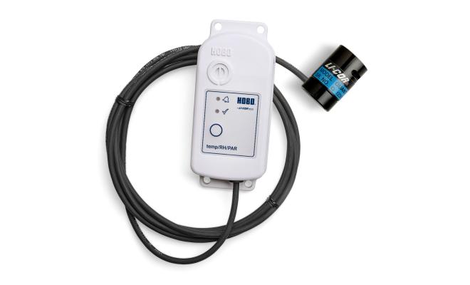 light sensor connected to a temp and humidity data logger via a cable against a white background