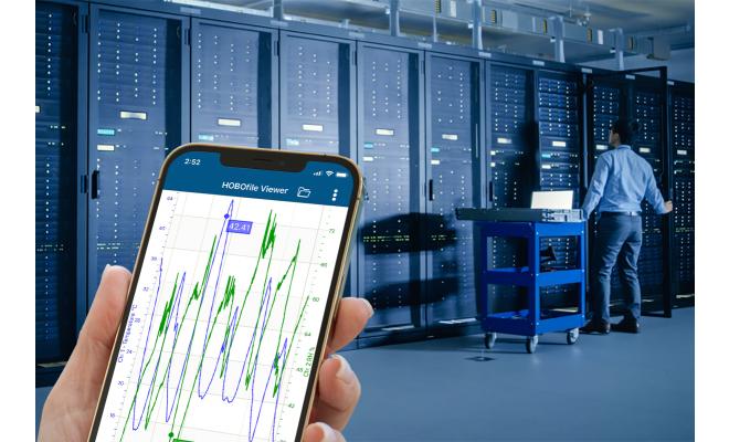 Phone in hand with app monitoring conditions in data center server room