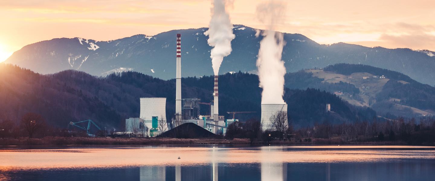 Nuclear plant with active emissions sits by a lake and emphasizes the critical importance of meeting environmental compliance requirements.