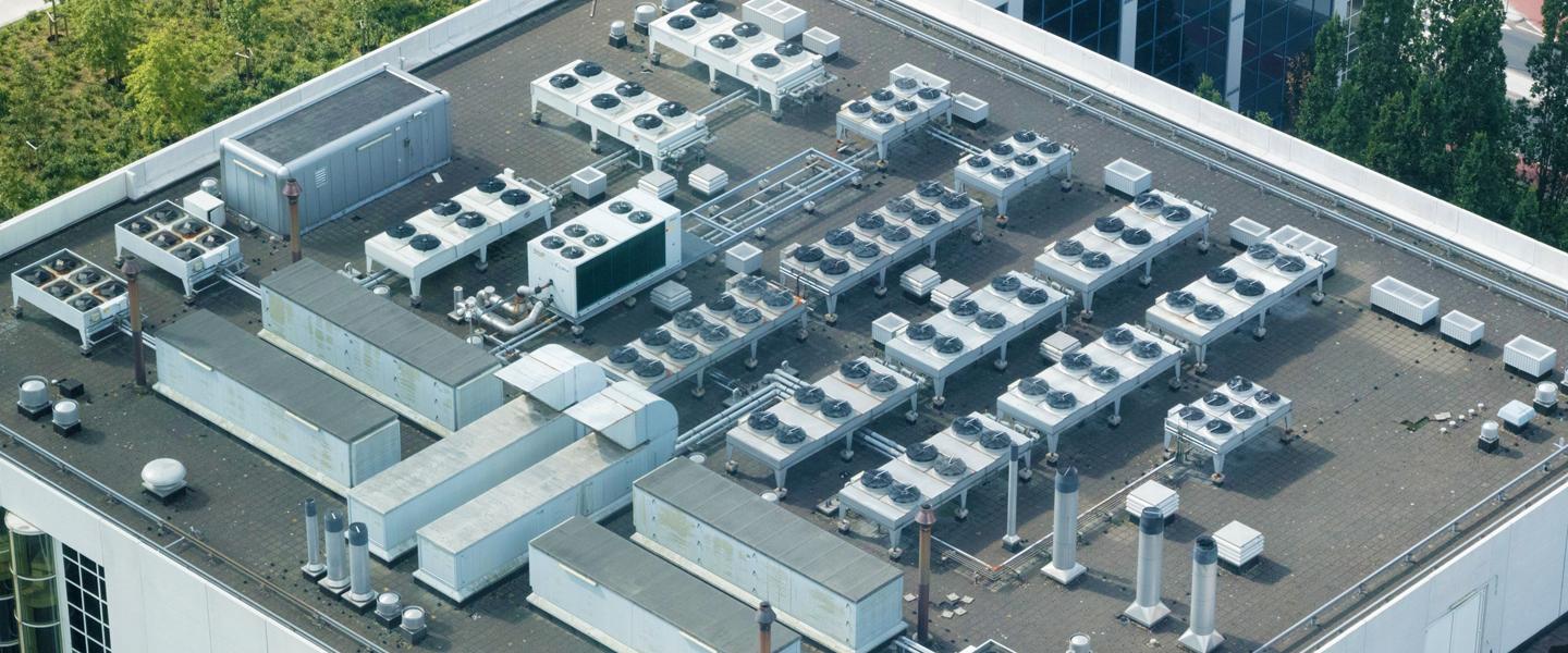 Aerial view of a commercial building rooftop showing many HVAC units