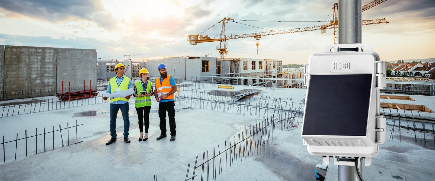 Construction workers on a job site at dusk with the RX2100 weather station in the foreground