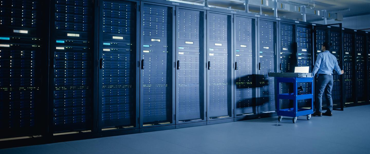 Man standing in front of large bank of data center equipment