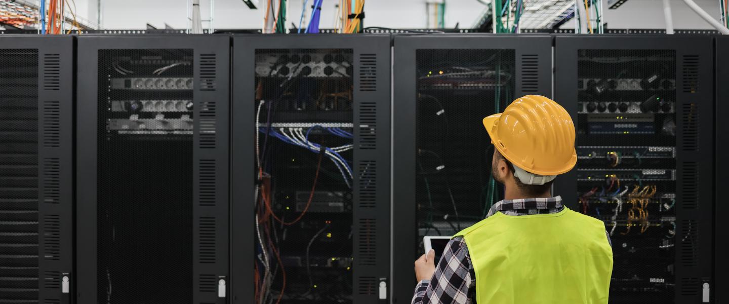 man in safety attire monitoring data center racks