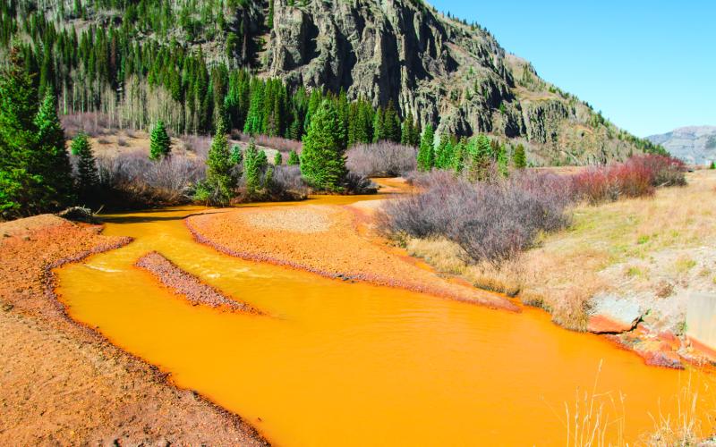 River runs red with mine tailings, severely impacting the aquatic ecosystem.