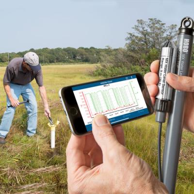 HOBO MX2001 installed in a marsh with mobile phone in forgeound with data results on screen
